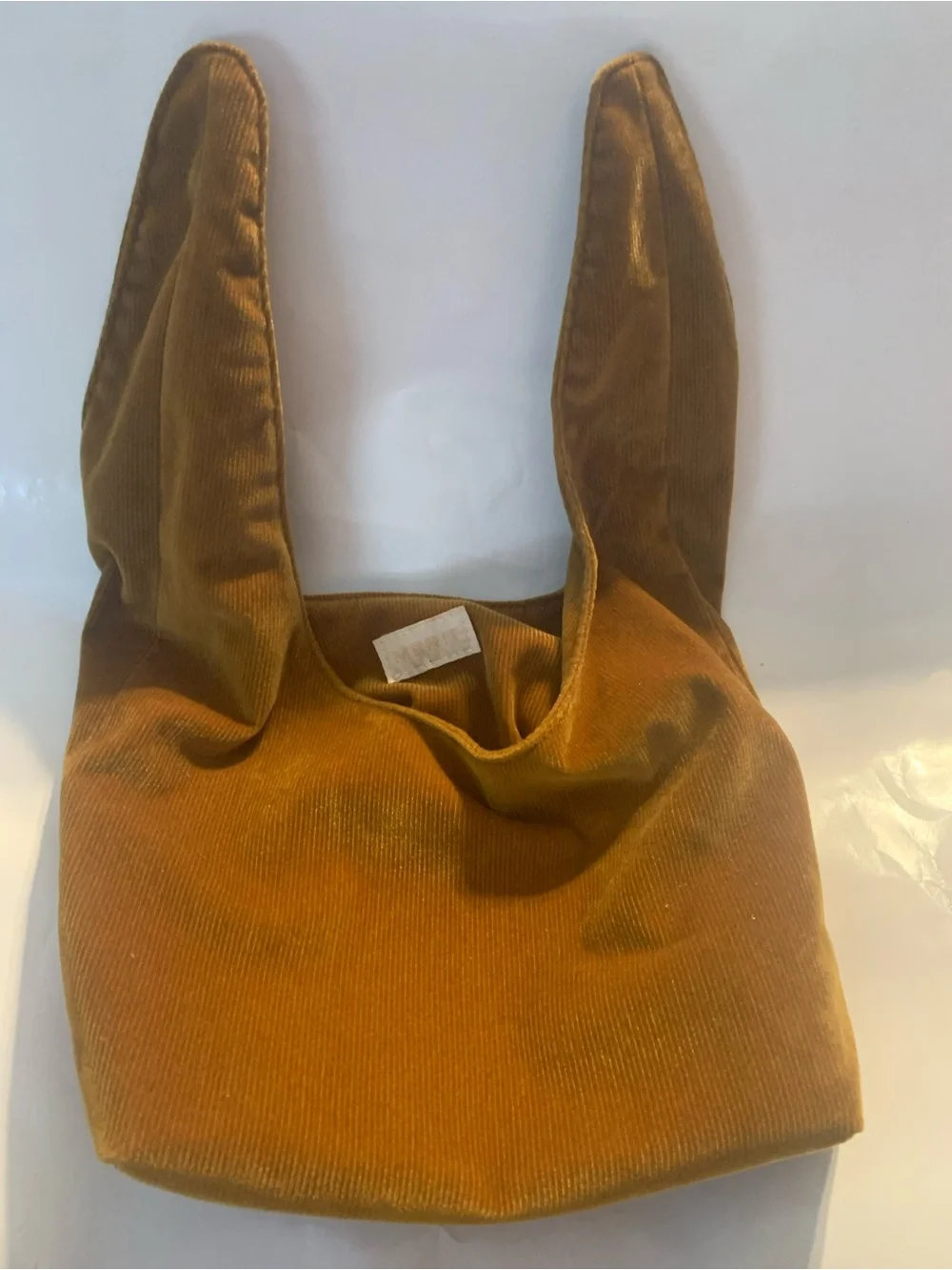 Merit Beauty Signature Bag in a golden brown or camel corduroy material